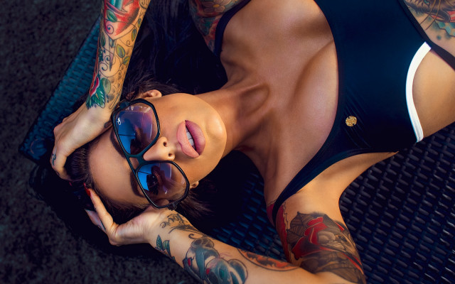 Tattooed woman laying sunglasses armor free wallpaper - medium preview image
