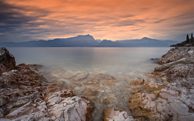 Rocky shore mountains sunset ocean free wallpaper - medium preview image