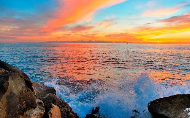 Sunset ocean boat rock outcropping free wallpaper - medium preview image