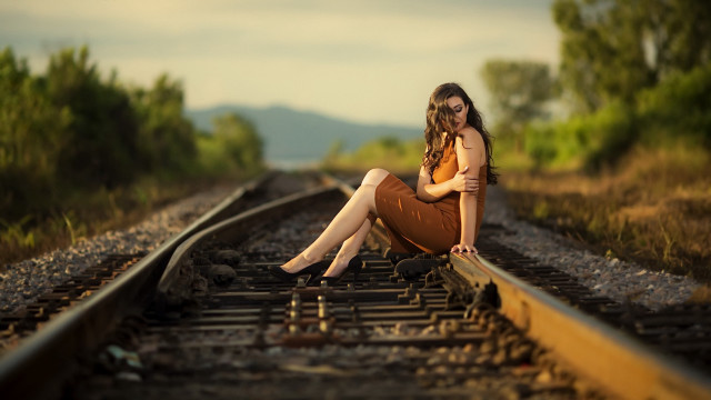 Woman sitting train track bokeh free wallpaper - medium preview image