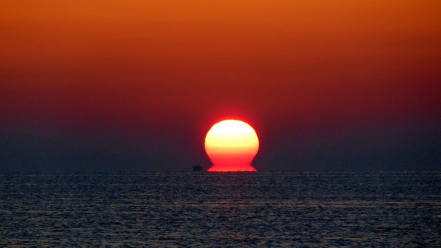 Orange sun over ocean surrealist free wallpaper - medium preview image