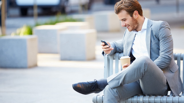 Man sitting coffee cellphone blurry free wallpaper - medium preview image