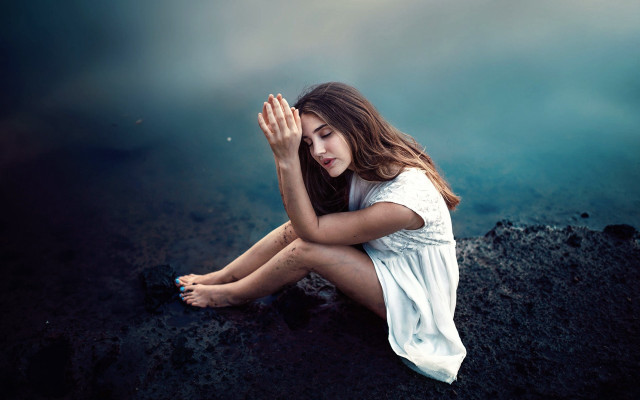 Woman sitting rock hands covered free wallpaper - medium preview image