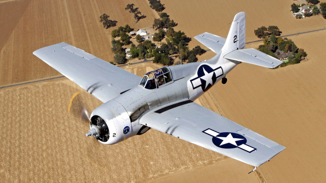 Small airplane flying over crops free wallpaper - medium preview image