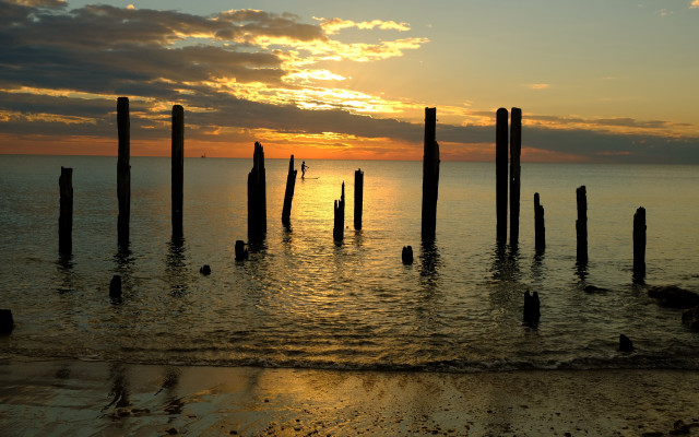 Sunset ocean poles shore people free wallpaper - medium preview image