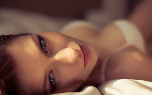 Woman laying bed blurry photorealistic free wallpaper - medium preview image