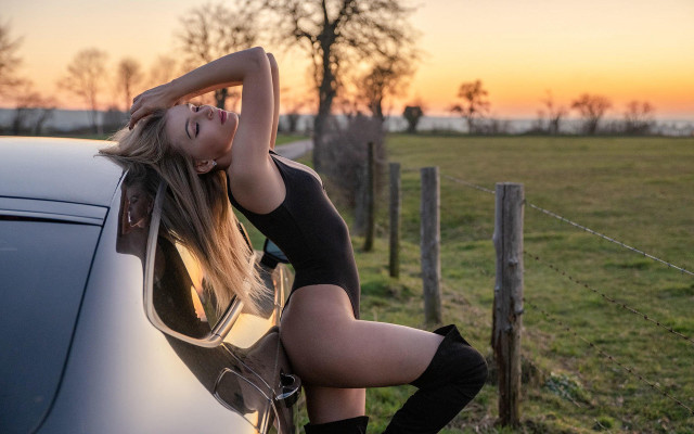 Woman leaning car field sunset free wallpaper - medium preview image