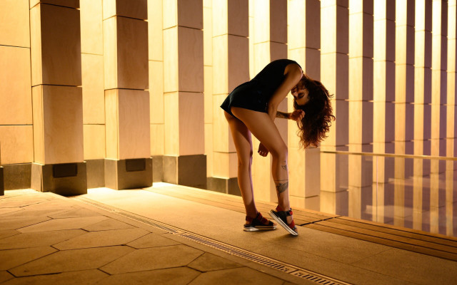 Woman leaning wall skirt sneakers free wallpaper - medium preview image