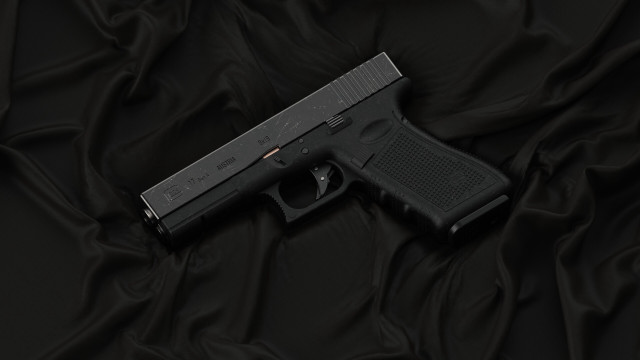 Black gun on wrinkled cloth free wallpaper - medium preview image