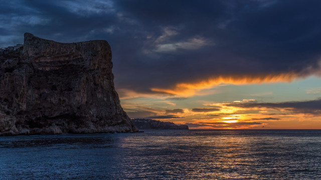 Rock outcropping sunset ocean boat free wallpaper - medium preview image