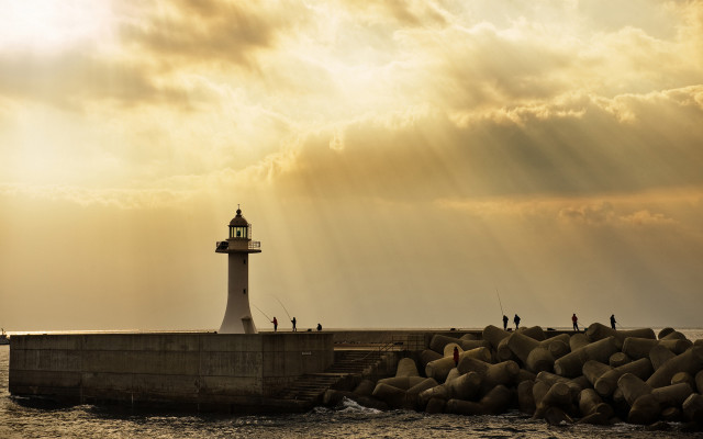 Lighthouse rocky pier sunset sunbeams free wallpaper - medium preview image