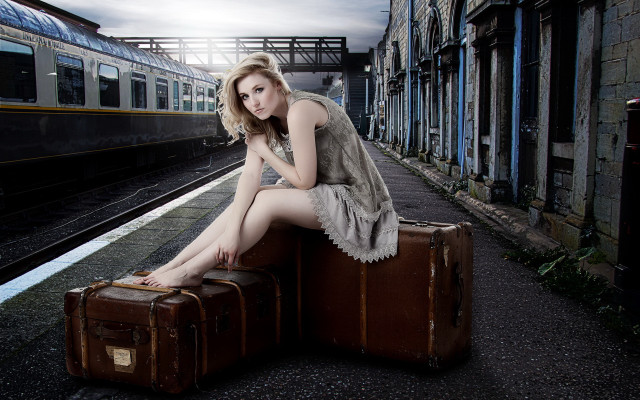 Woman sitting suitcase train station free wallpaper - medium preview image