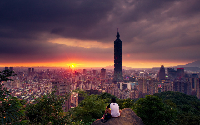 Person sitting rock overlooking city free wallpaper - medium preview image