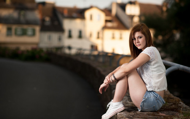 Woman sitting ledge street buildings free wallpaper - medium preview image