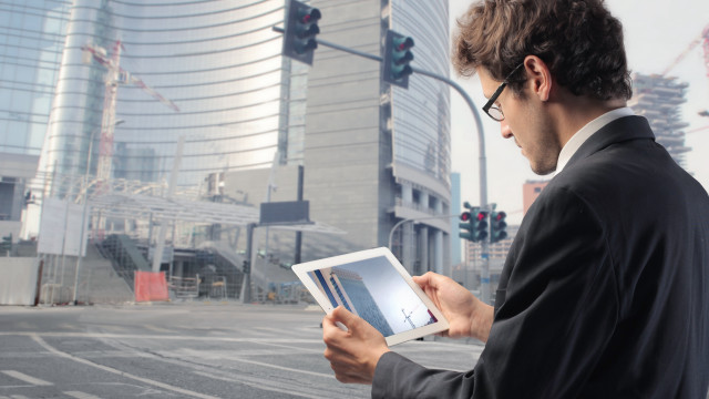 Man suit holding tablet city free wallpaper - medium preview image