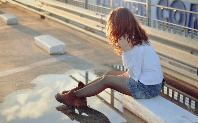 Woman sitting ledge cityscape boots free wallpaper - medium preview image