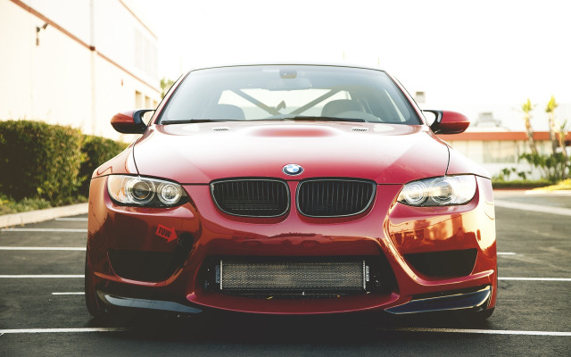 Red car parked building bushes free wallpaper - medium preview image