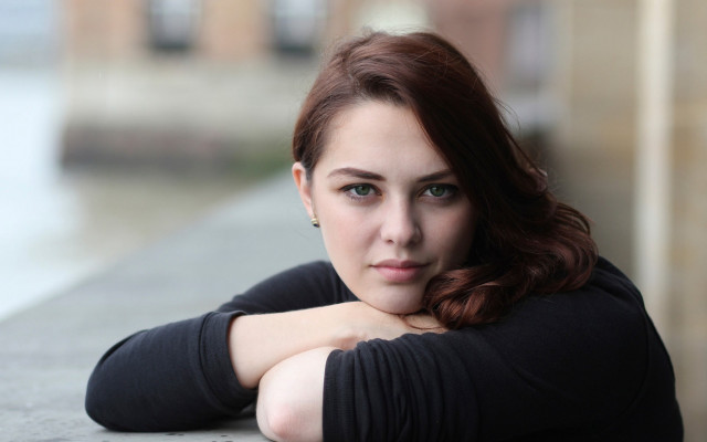 Woman leaning wall crossed arms #2 free wallpaper - medium preview image