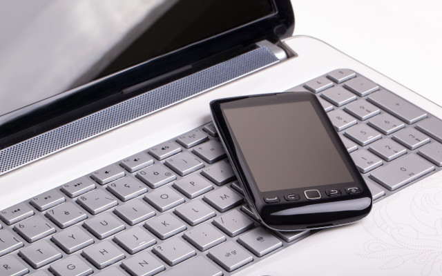Cell phone on keyboard with free wallpaper - medium preview image