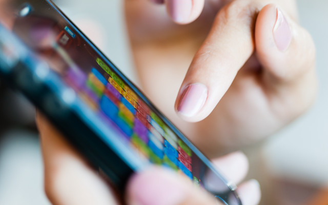 Woman holding cellphone blurry background free wallpaper - medium preview image