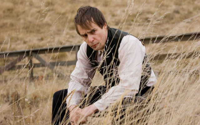 Man kneeling grass field hand free wallpaper - medium preview image