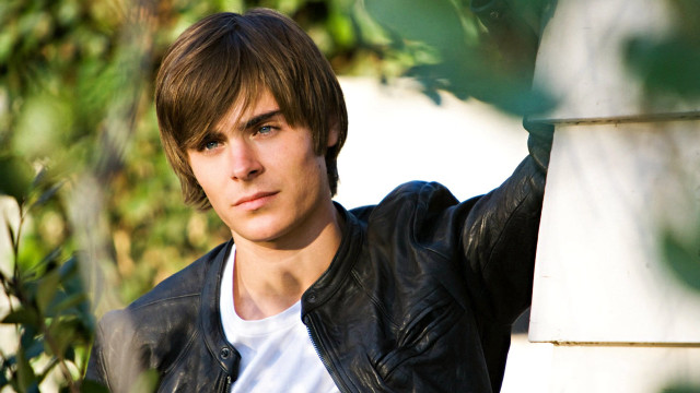 Young man leaning wall serious #2 free wallpaper - medium preview image