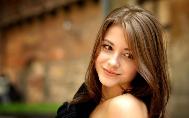 Woman smiling brick wall bokeh free wallpaper - medium preview image