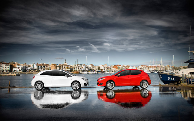 Two cars waterfront cityscape promotional free wallpaper - medium preview image