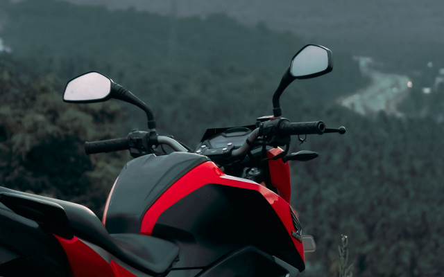 Red motorcycle hillside forest building free wallpaper - medium preview image