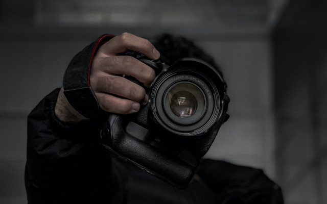 Man holding camera dark room #2 free wallpaper - medium preview image