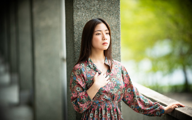 Woman leaning wall serious portrait #3 free wallpaper - medium preview image