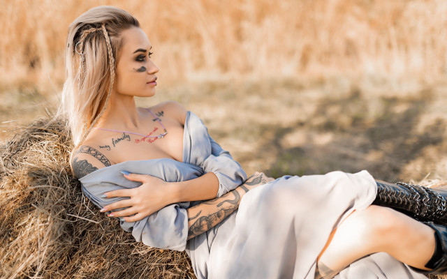 Tattooed woman hay bale field free wallpaper - medium preview image
