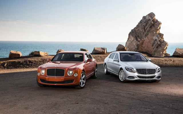 Two luxury trucks rocky beach free wallpaper - medium preview image