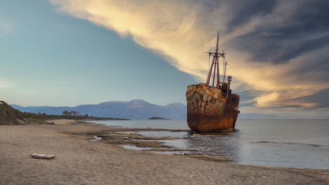 Ship beach ocean mountains clouds free wallpaper - medium preview image