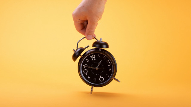 Hand holding black alarm clock free wallpaper - medium preview image