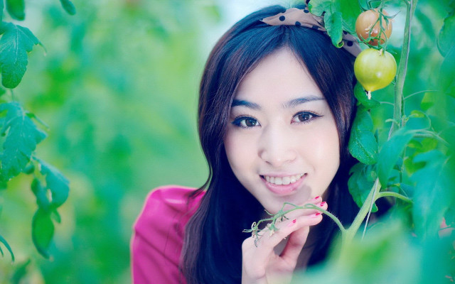 Woman pink shirt holding plant free wallpaper - medium preview image