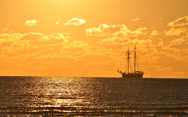 Sailboat ocean sunset clouds yellow free wallpaper - medium preview image
