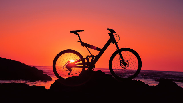 Bike parked rock sunset ocean free wallpaper - medium preview image