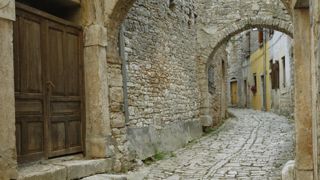 Narrow cobblestone street romanque arch free wallpaper - medium preview image