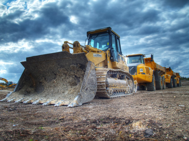 Bulldozer parked field cloudy sky free wallpaper - medium preview image