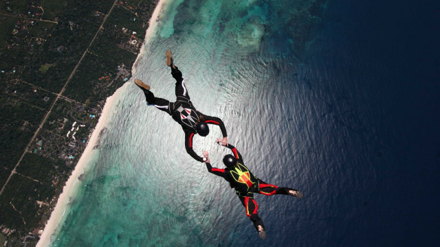 Flying people ocean land below free wallpaper - medium preview image