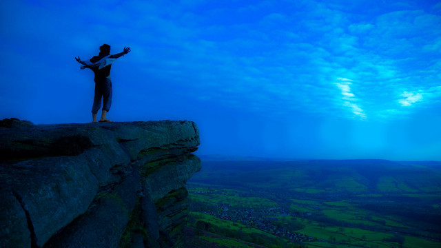 Cliff man outstretched arms valley free wallpaper - medium preview image