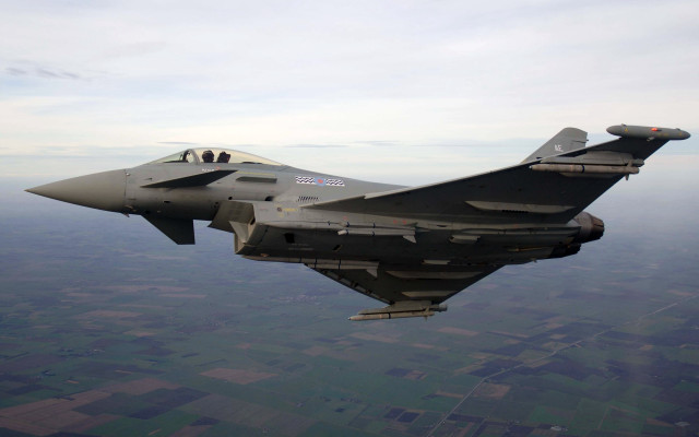 Military jet flying over field free wallpaper - medium preview image