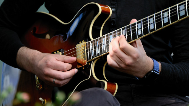 Man playing guitar black shirt free wallpaper - medium preview image