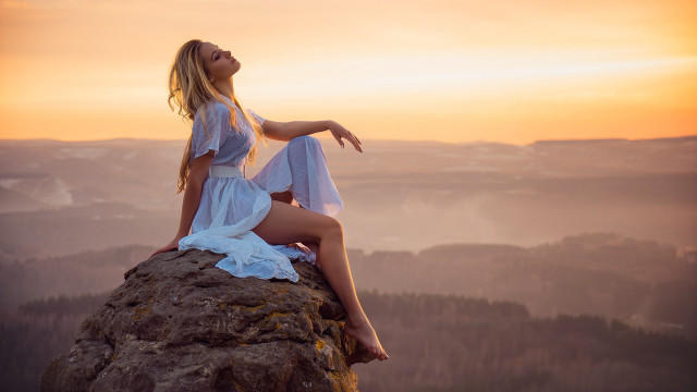 Woman sitting rock beach sunset free wallpaper - medium preview image