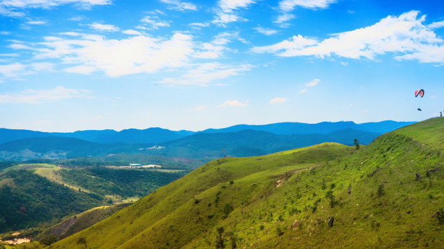 Kite flying grassy hill mountains free wallpaper - medium preview image