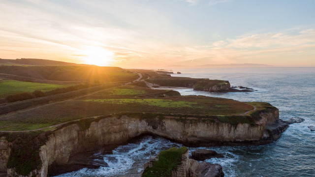 Sunset over water cliff grassy #2 free wallpaper - medium preview image