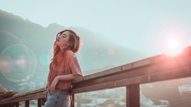Woman leaning rail blowing hair free wallpaper - medium preview image
