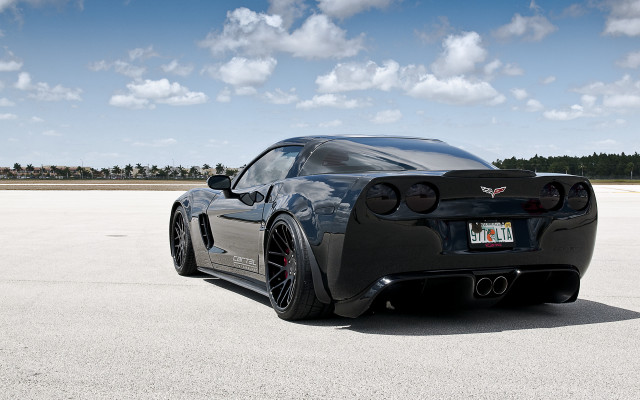 Black sports car concrete lot free wallpaper for desktop - medium preview image