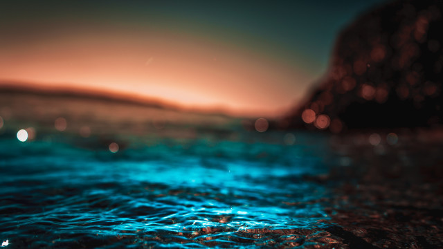Blurry water sunset rock bioluminescence free wallpaper - medium preview image